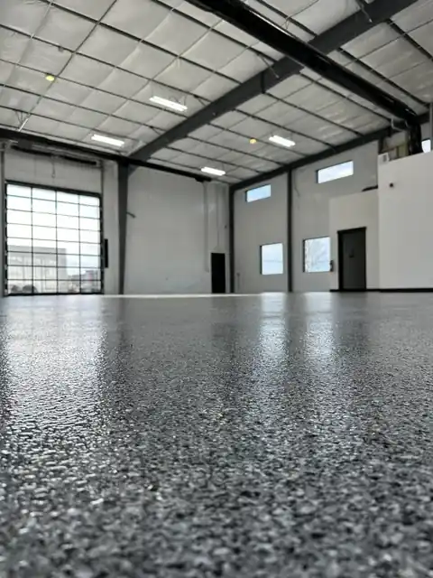 Flake epoxy floor inside a large steel-framed shop